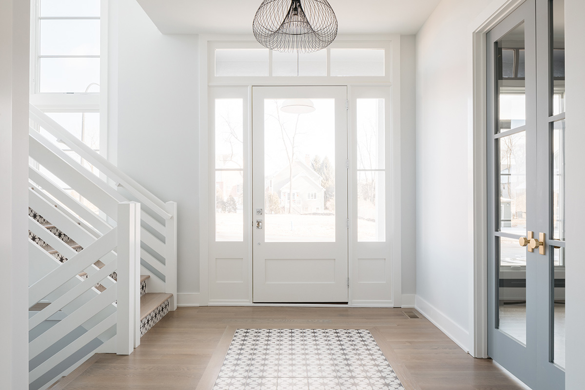 Entry way with white front door and sidelights bringing in natural light.