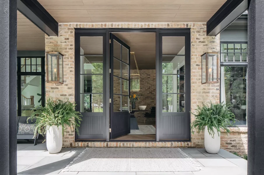 Large front door with sidelights with brick surrounding the door.